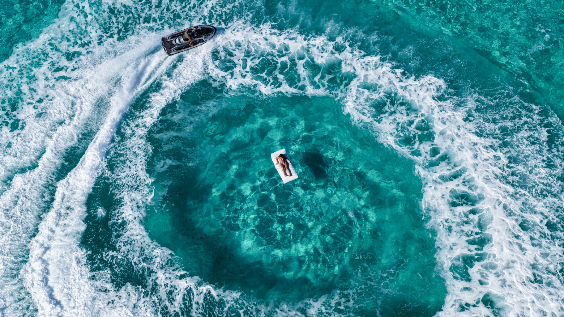 Aerial of a jet ski circling a floating guest