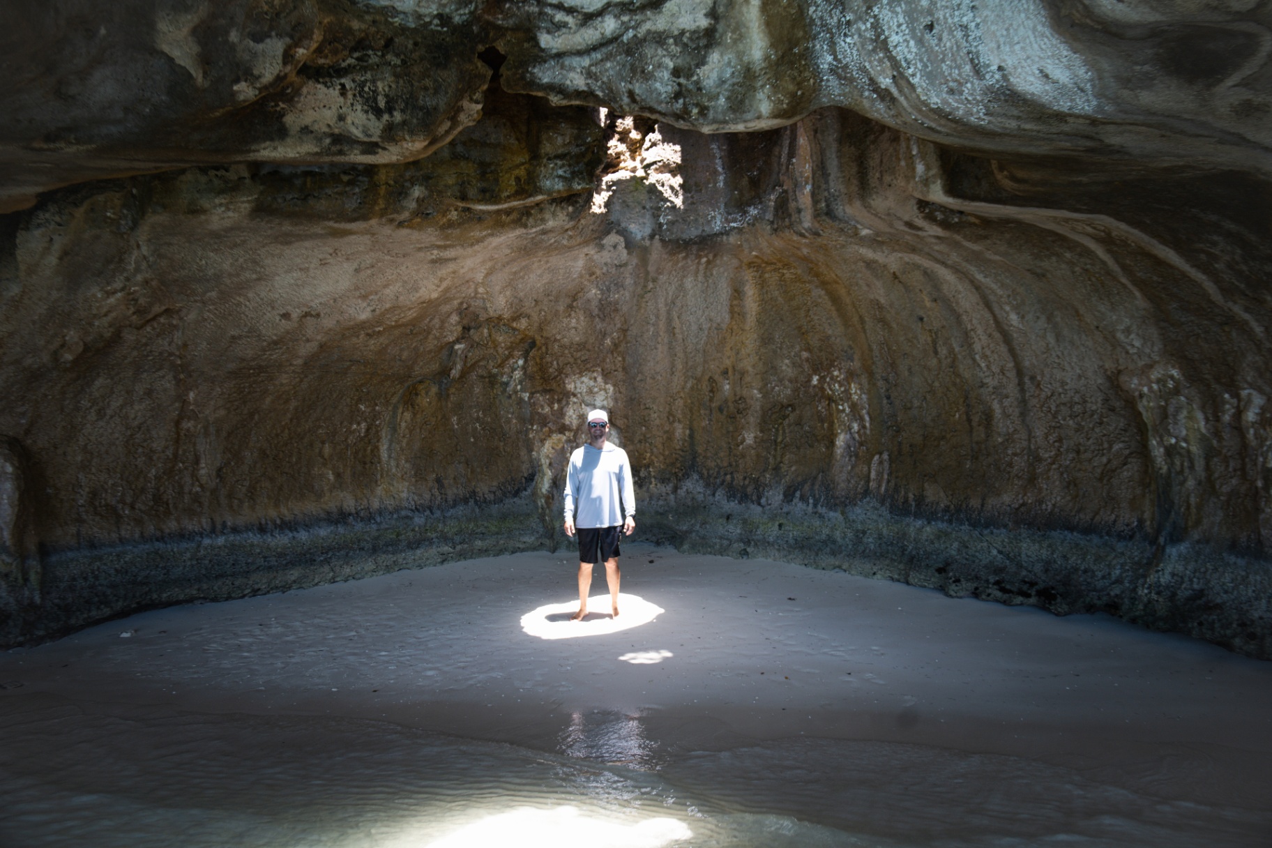 Standing inside a sea cave with a beam of light
