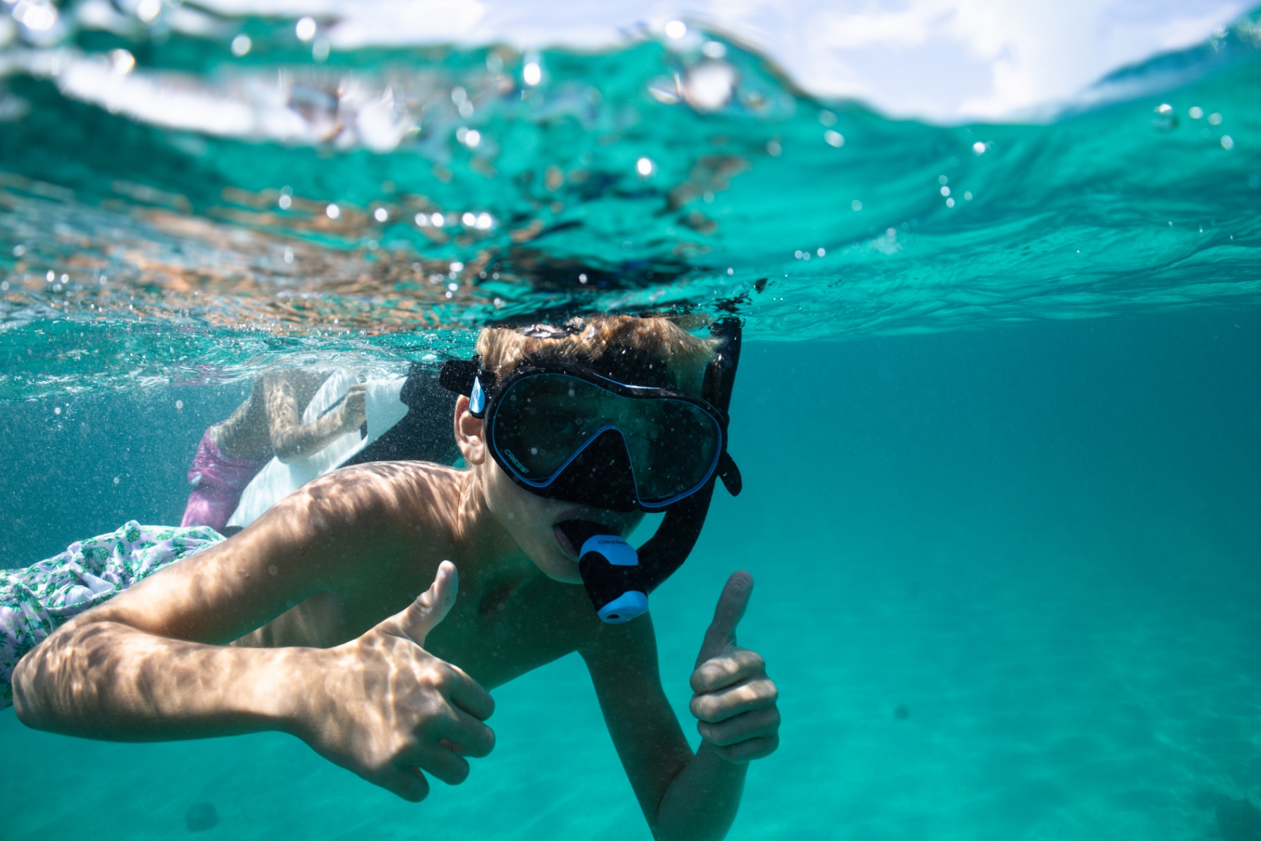 Young snorkeler giving a thumbs up underwater